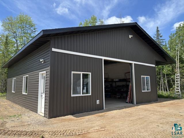 3454 Anderson Road Hibbing, MN 55746 - Photo 29 of 31 Modern utility building featuring dark siding, white trim, and a large sliding door