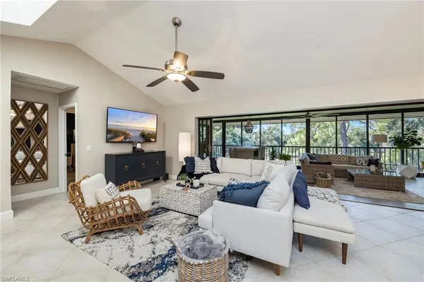 a living room with furniture fireplace and a large window