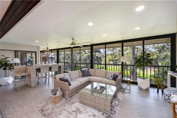 a living room with furniture flat screen tv and a large window