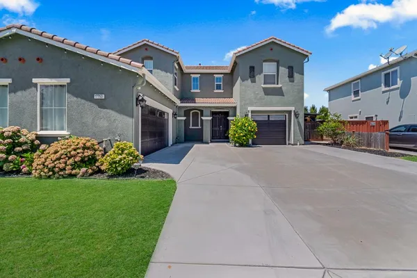 a front view of a house with a garden and yard
