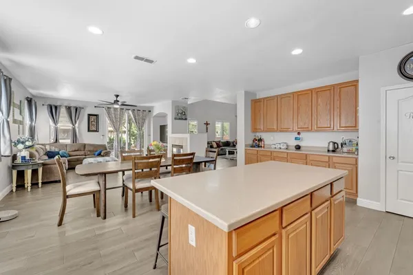 a kitchen with stainless steel appliances kitchen island granite countertop a dining table and chairs