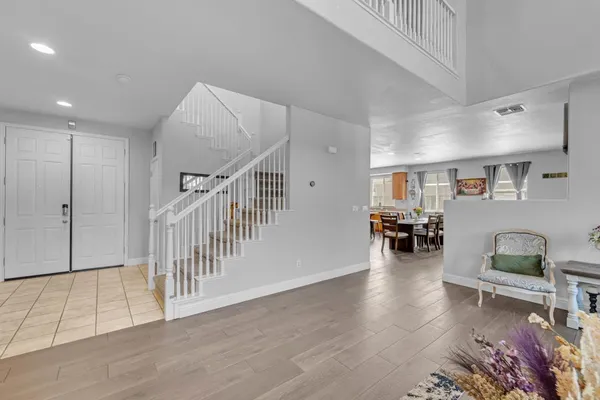 a kitchen with stainless steel appliances granite countertop a refrigerator a sink dishwasher and a stove with wooden floor