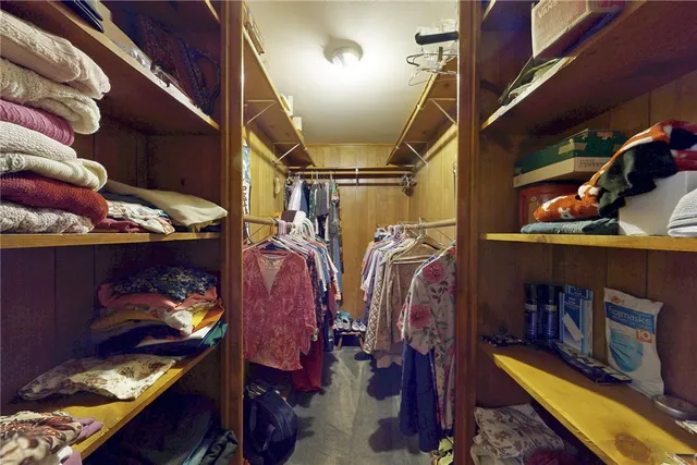 a view of walk in closet with clothes and shoes