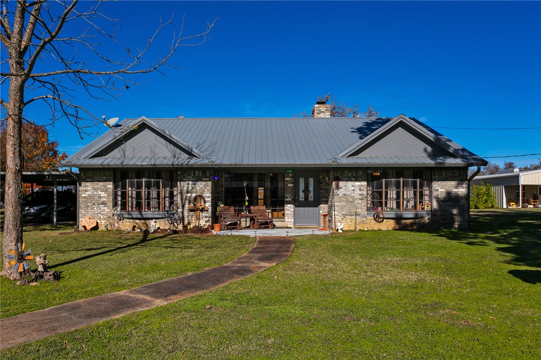 409 Morgan Street Franklin, TX 77856 - Photo 4 of 40 a front view of a house with a garden