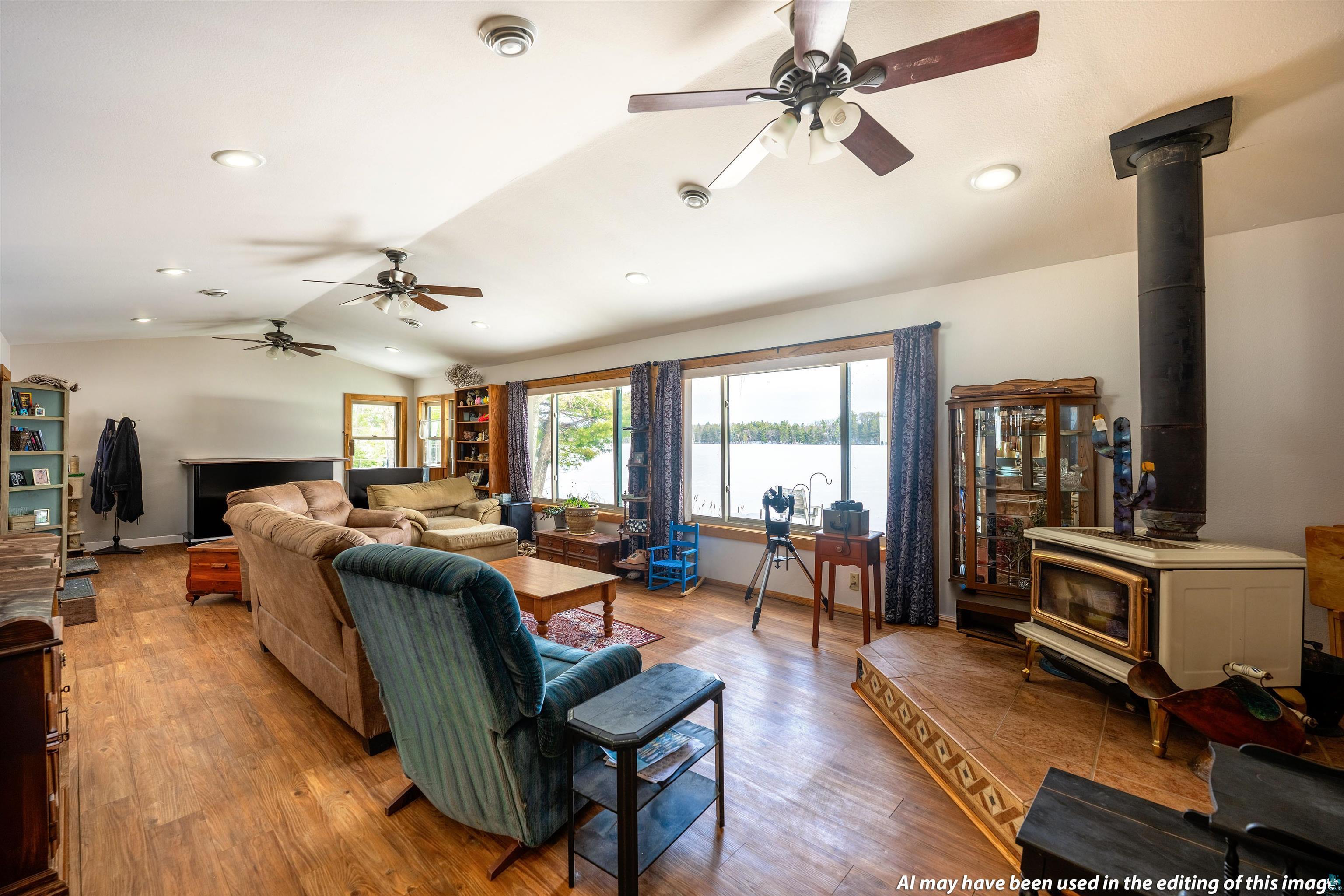 6030 Lake Ahmeek Road Hughes, WI 54847 - Photo 5 of 24 Living area featuring a ceiling fan, lofted ceiling, wood finished floors, a water view, and recessed lighting