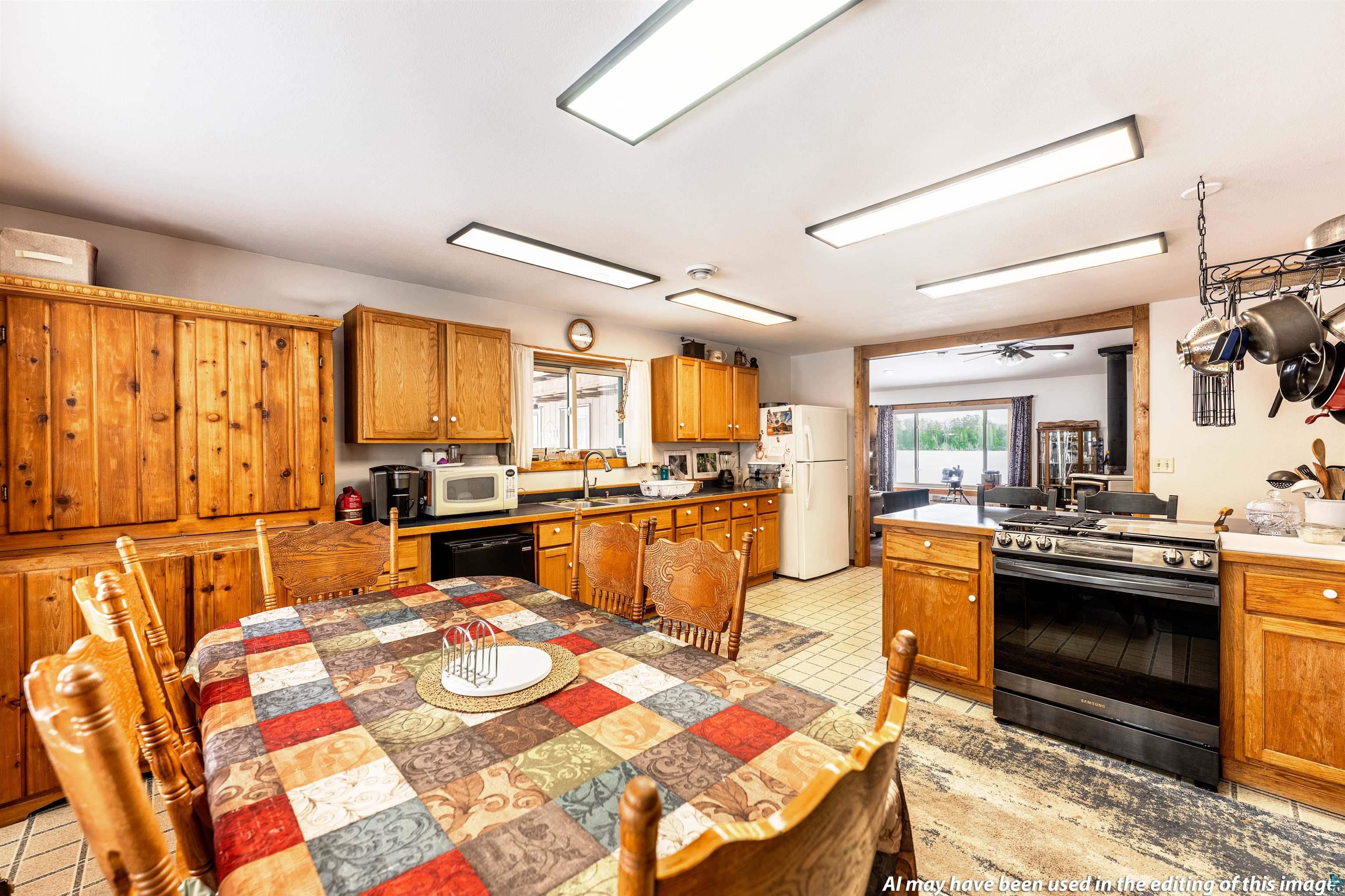 6030 Lake Ahmeek Road Hughes, WI 54847 - Photo 7 of 24 Kitchen with white appliances, wood finish cabinets, and light countertops