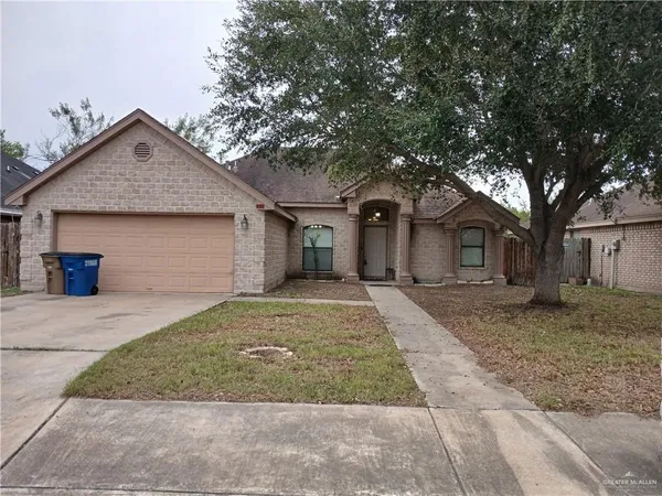 a front view of a house with a yard and trees