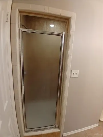 an empty room with a chandelier fan and windows