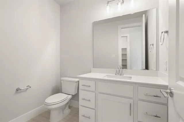 a bathroom with a toilet sink vanity and mirror
