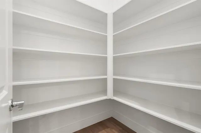a view of walk in closet with empty racks