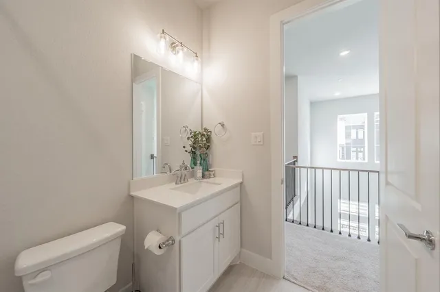 a bathroom with a double vanity sink a toilet and shower