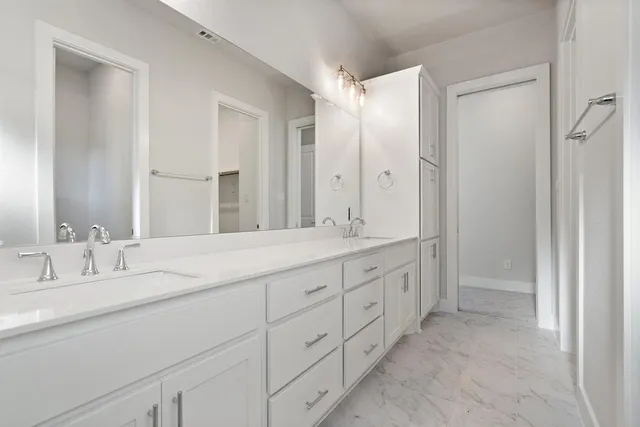a bathroom with double sink and a mirror