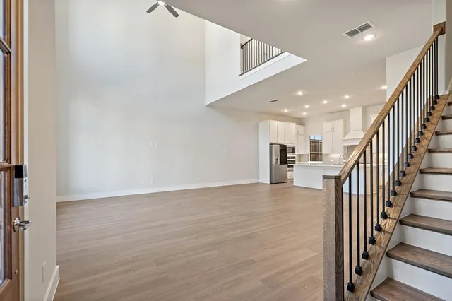 a view of a hallway with wooden floor and staircase