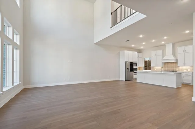 a view of kitchen with kitchen island a sink wooden floor and a refrigerator
