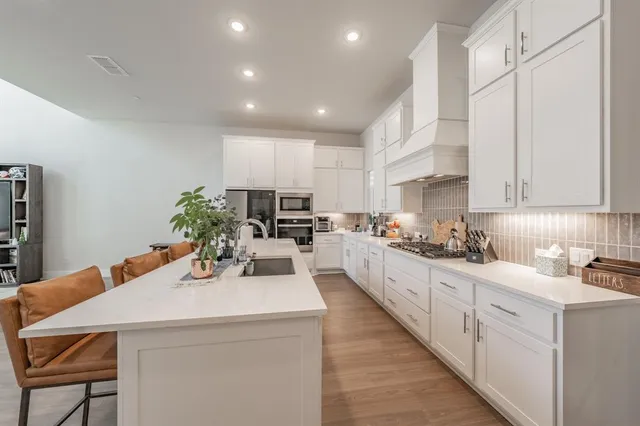 a kitchen with refrigerator a microwave and cabinets