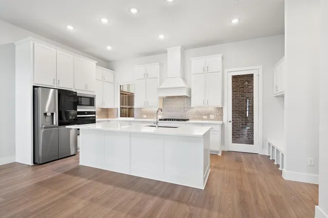 a kitchen with stainless steel appliances a refrigerator and a stove top oven