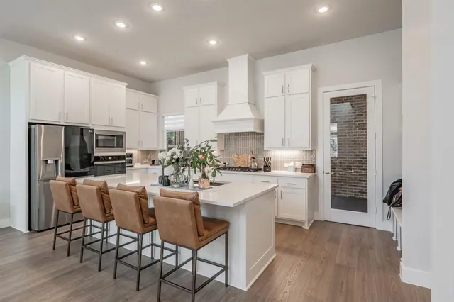 a kitchen with granite countertop white cabinets and stainless steel appliances