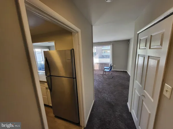 a view of a refrigerator in kitchen and entryway