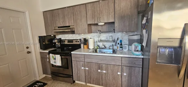 a kitchen with a sink cabinets and appliances