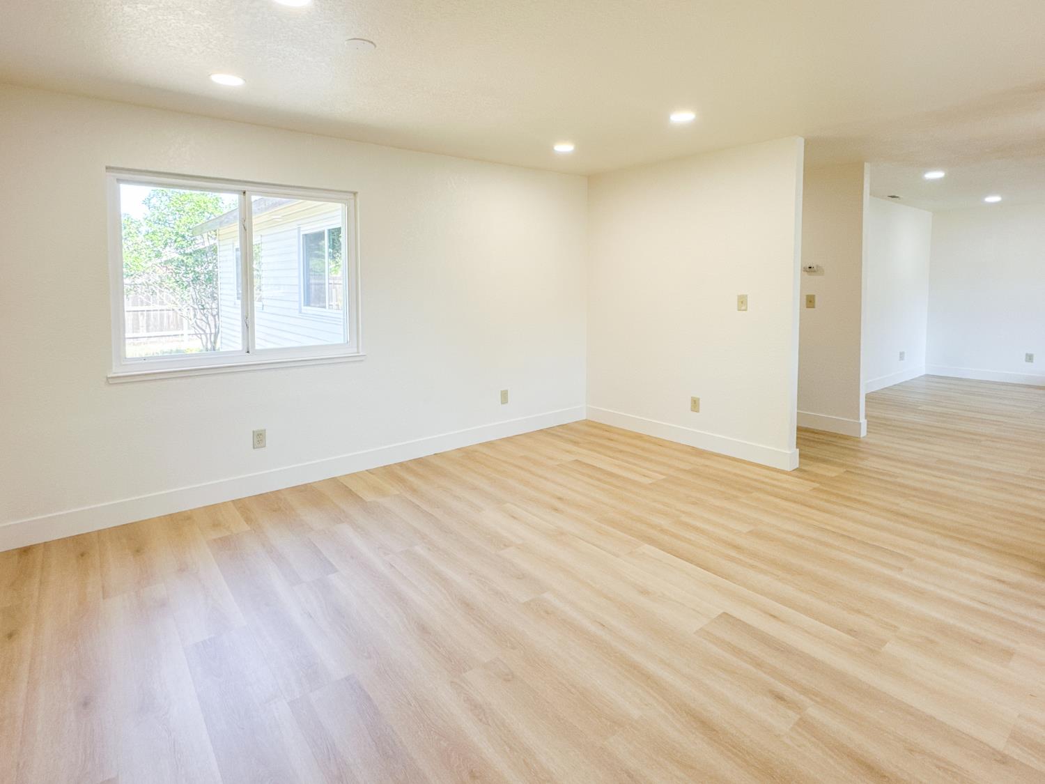 1465 West Tuolumne Road Turlock, CA 95382 - Photo 6 of 7 an empty room with wooden floor and windows