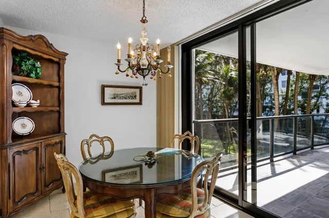 a dining room with furniture a chandelier and window