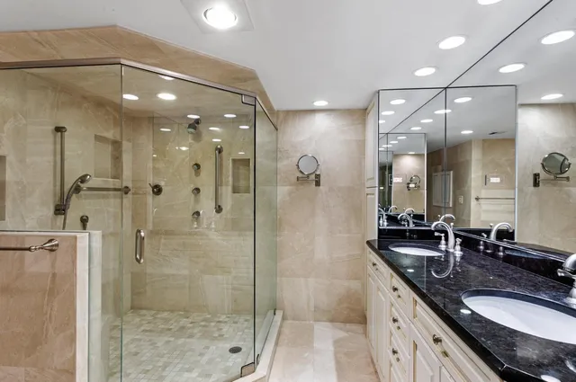 a bathroom with a granite countertop sink a large mirror and shower