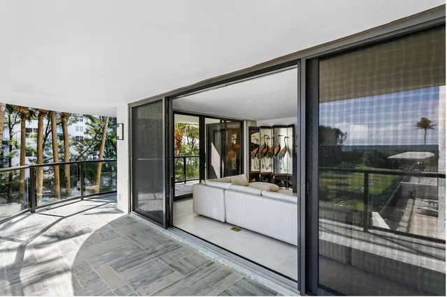 a bedroom with a balcony a bed and a glass door