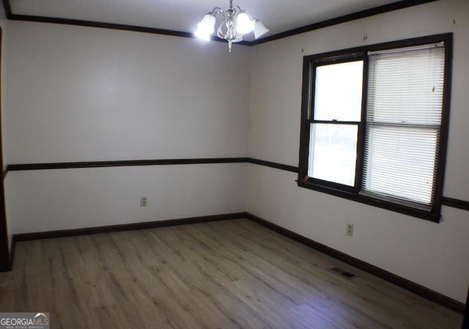 118 Whipoorwill Way Dublin, GA 31021 - Photo 14 of 28 a view of an empty room with wooden floor and a window