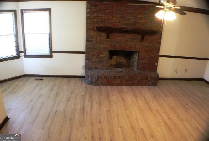 118 Whipoorwill Way Dublin, GA 31021 - Photo 9 of 28 an empty room with wooden floor fireplace and windows