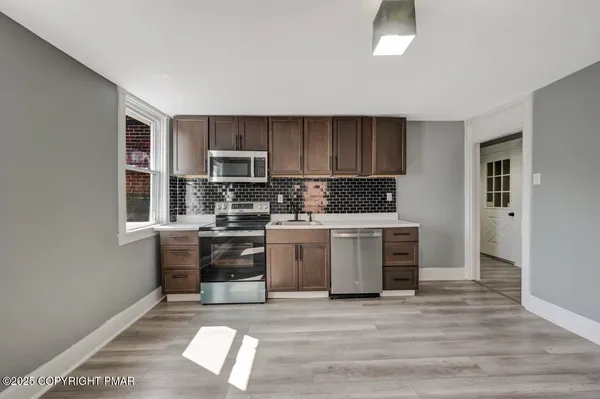 a kitchen with granite countertop a stove top oven and cabinets