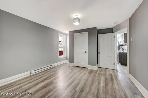 a view of an empty room with wooden floor