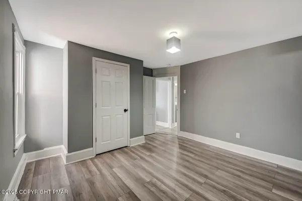 a view of a room with wooden floor and a window