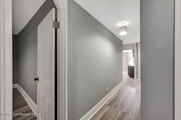 a view of a hallway with wooden floor