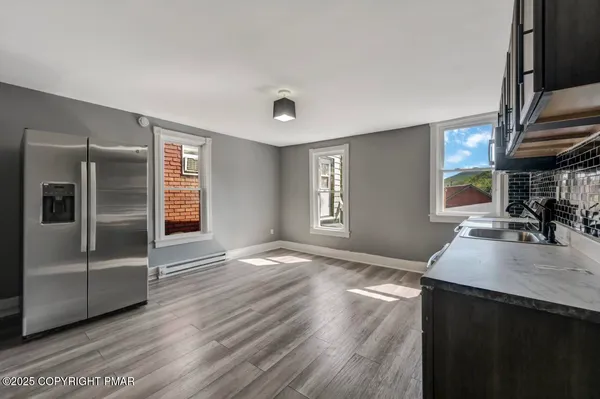 a kitchen with a refrigerator stove top oven and sink