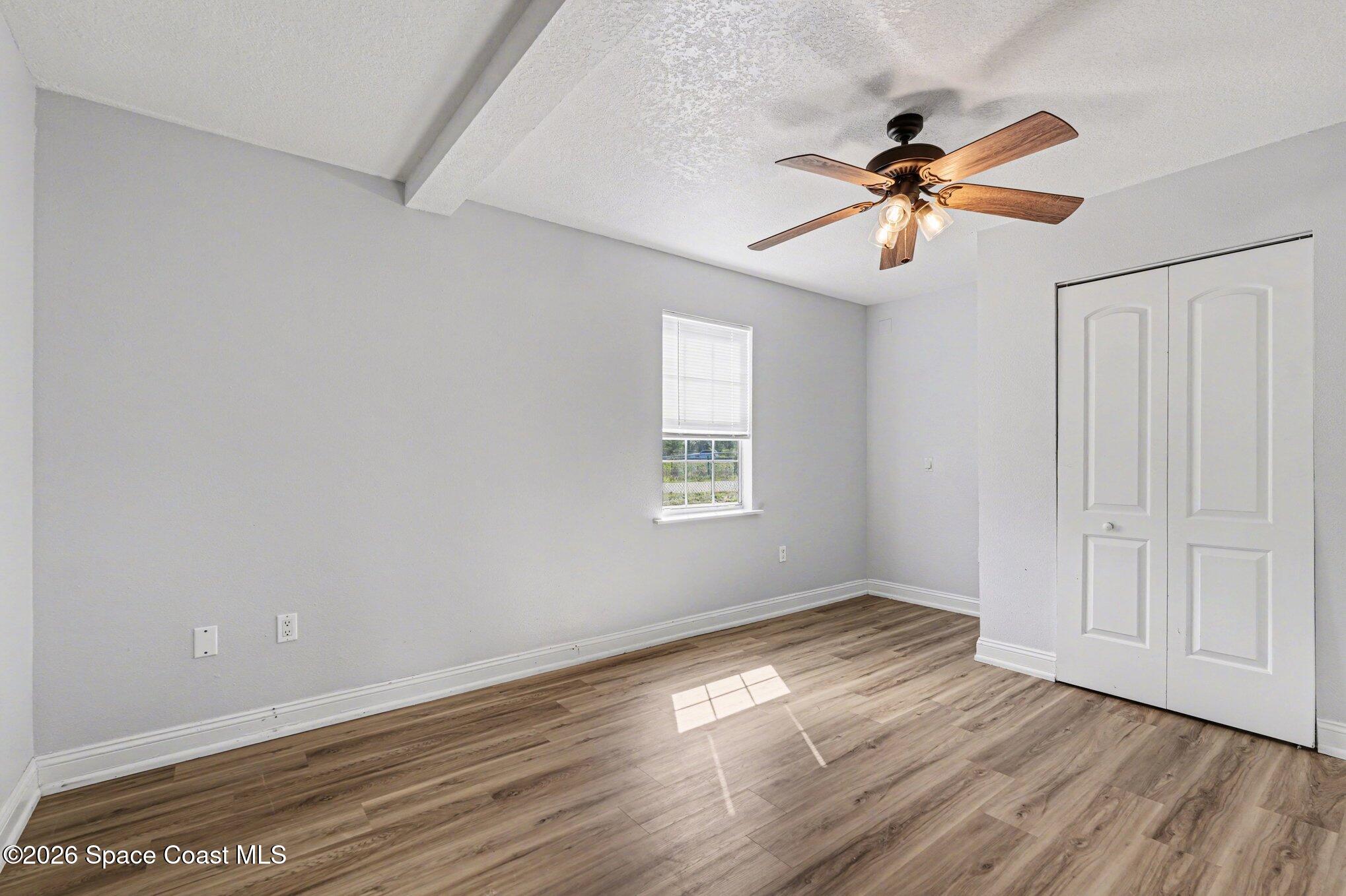 4950 Blounts Ridge Road Mims, FL 32754 - Photo 16 of 40 a view of empty room with wooden floor and fan