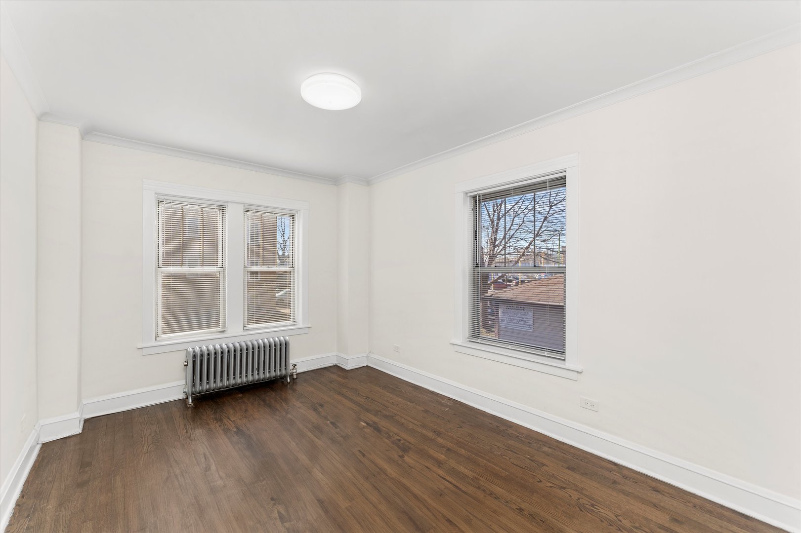 4744 West Roscoe Street, Unit 2 Chicago, IL 60641 - Photo 13 of 14 an empty room with wooden floor and windows