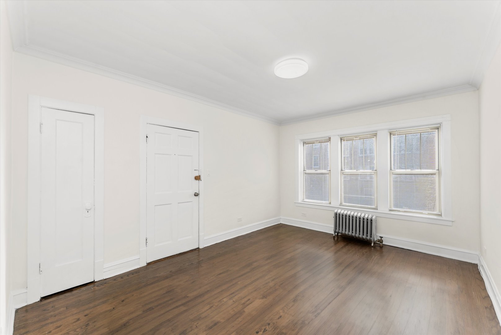 4744 West Roscoe Street, Unit 2 Chicago, IL 60641 - Photo 9 of 14 an empty room with wooden floor and white walls
