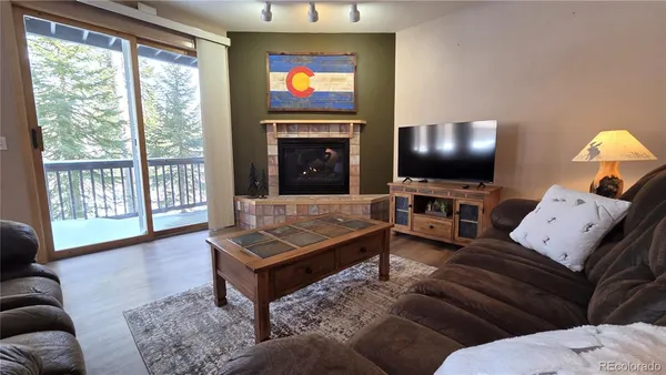 a living room with furniture a flat screen tv and a fireplace
