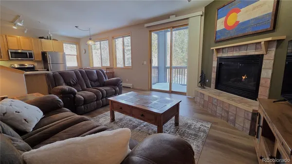 a living room with furniture a fireplace and a flat screen tv