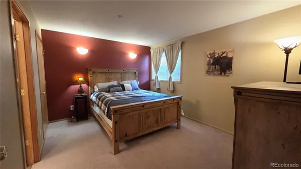 a bed sitting in a room next to a lamp