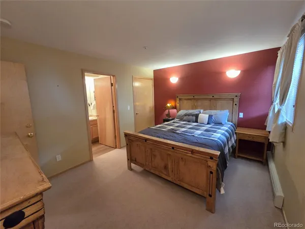 a bed sitting in a room next to a lamp