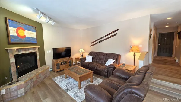 a living room with furniture a flat screen tv and a fireplace