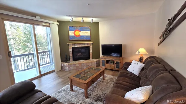 a living room with furniture a flat screen tv and a fireplace