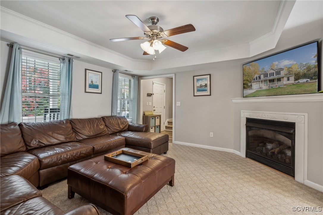1121 Coachpoint Road Hartfield, VA 23071 - Photo 12 of 46 Carpeted living room featuring crown molding, a he