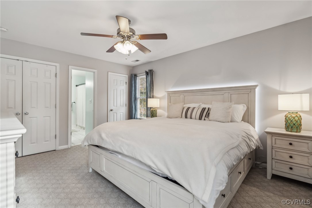 1121 Coachpoint Road Hartfield, VA 23071 - Photo 20 of 46 Carpeted bedroom with ceiling fan and ensuite bath