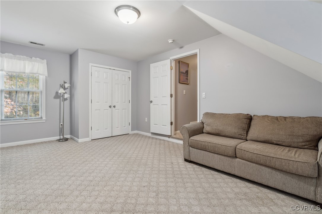 1121 Coachpoint Road Hartfield, VA 23071 - Photo 25 of 46 Carpeted living room with lofted ceiling
