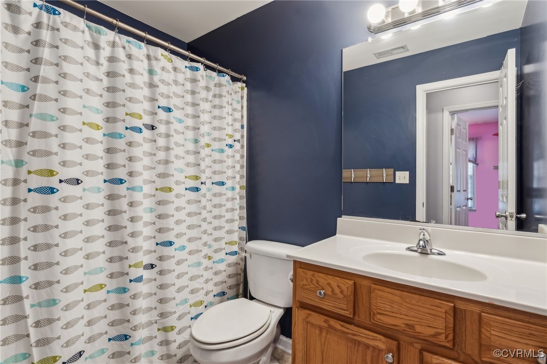 1121 Coachpoint Road Hartfield, VA 23071 - Photo 30 of 46 Bathroom with walk in shower, vanity, and toilet