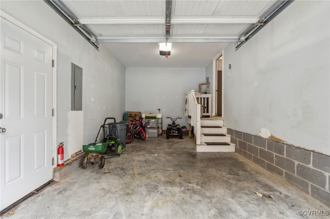 1121 Coachpoint Road Hartfield, VA 23071 - Photo 32 of 46 Garage with electric panel and a garage door opene