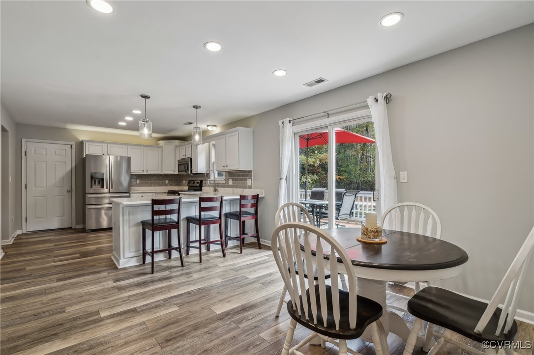 1121 Coachpoint Road Hartfield, VA 23071 - Photo 6 of 46 Dining space featuring sink and light hardwood / w