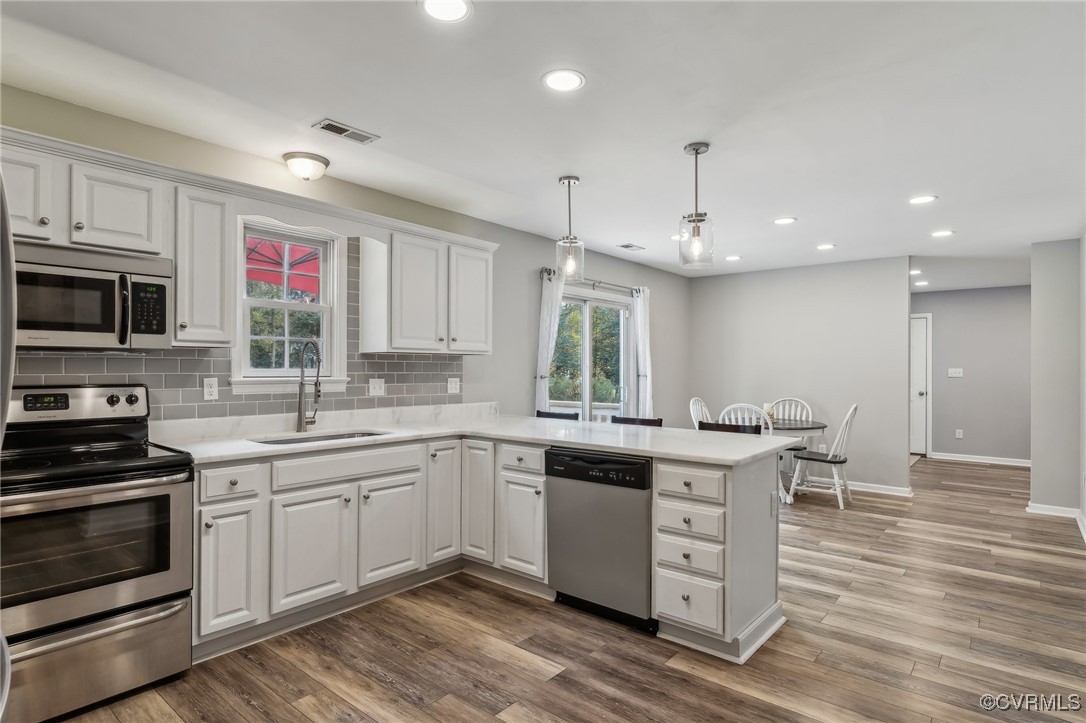 1121 Coachpoint Road Hartfield, VA 23071 - Photo 9 of 46 Kitchen with stainless steel appliances, hardwood